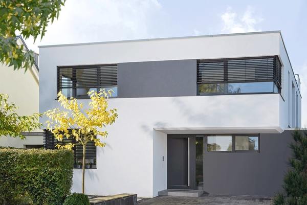 Modernes Einfamilienhaus mit Flachdach und großen Fenstern im minimalistischen Stil.